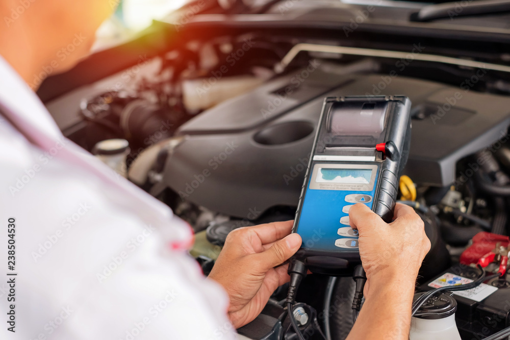 technician are conducting car check for car repair. with sun light