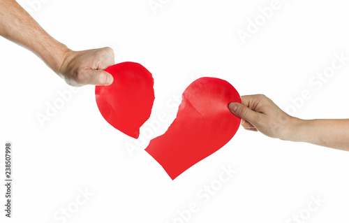 The hands of people tearing the heart apart. Valentine's day concept. Torn heart. On isolated background