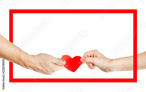 The hands of people hold a red heart in a red frame. Valentines day relationship concept. On isolated background