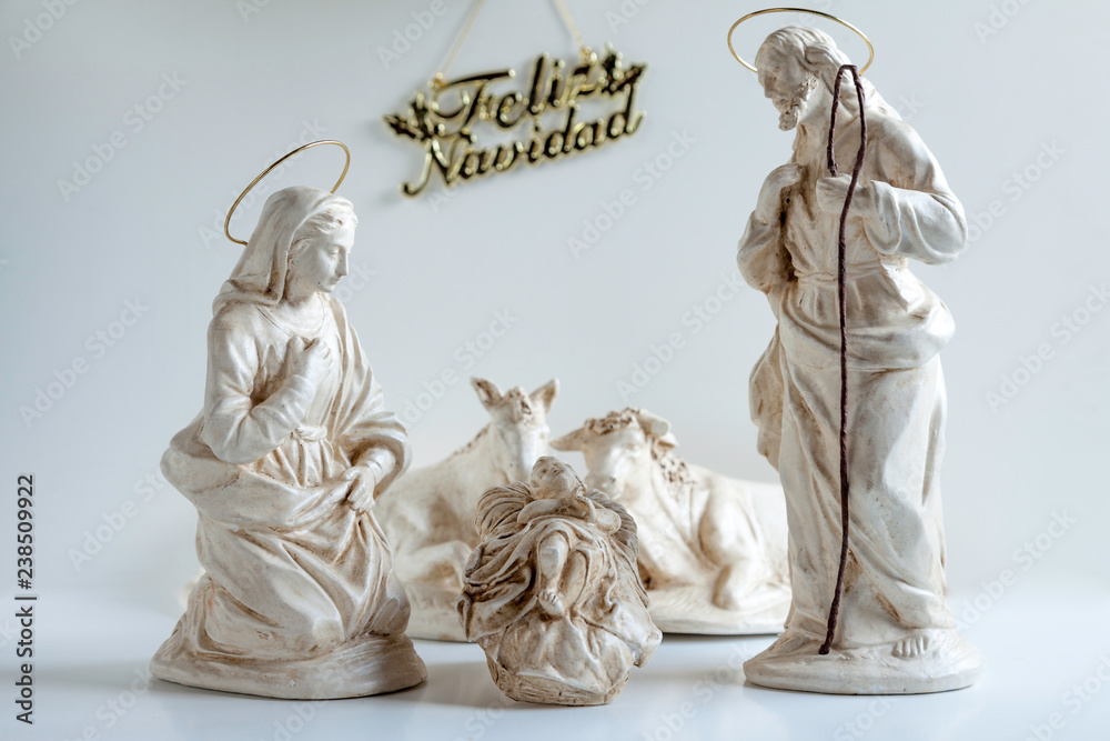 Christmas Manger scene with ceramic figurines Jesus, Mary and Joseph and feliz navidad