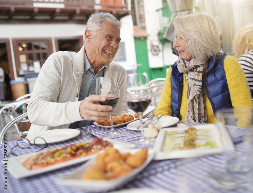 Attractive senior couple eating tapas outdoors