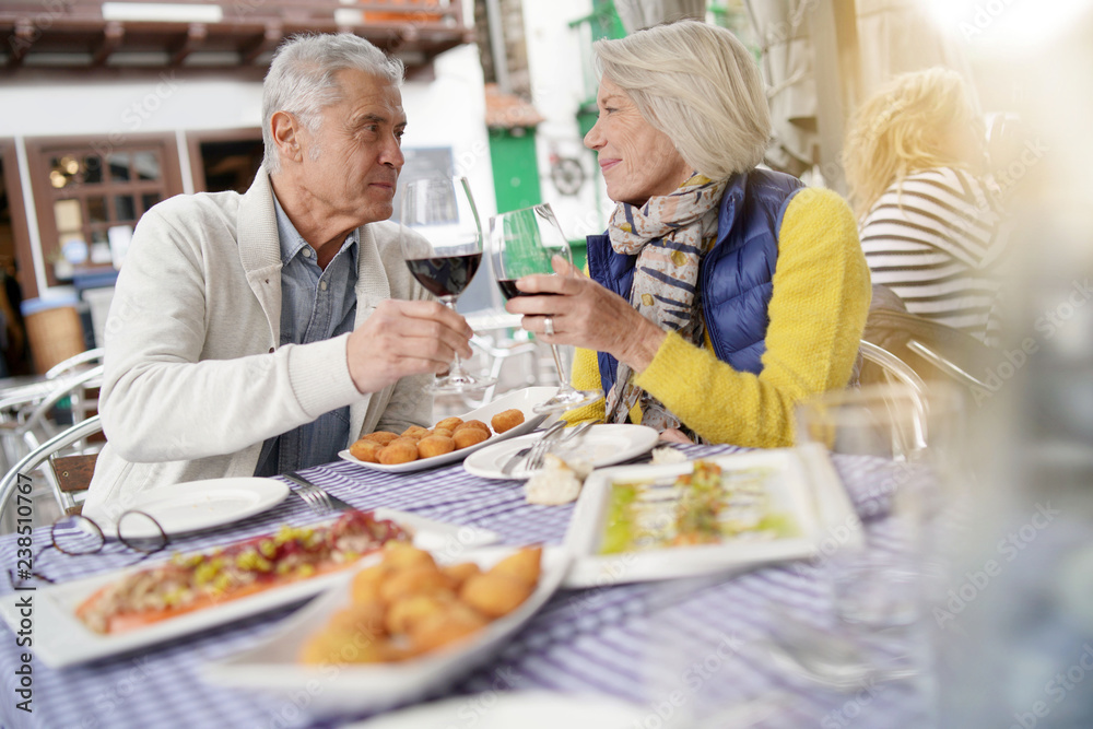Attractive senior couple eating tapas outdoors Attractive senior couple eating tapas outdoors