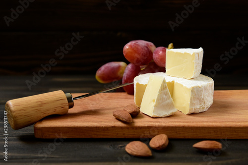 Cheese and grapes on a dark background