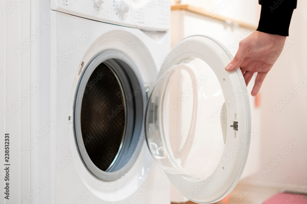 close up hand launch set and start washing machine laundry at home bathroom b close up hand launch set and start washing machine laundry at home bathroom b