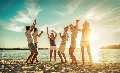 Happiness Friends funny dance on the beach under sunset sunlight
