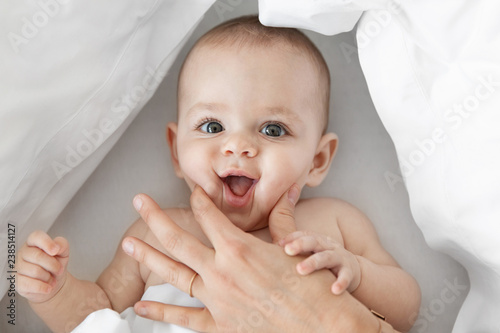 Mother's hand squishy baby's cheeks