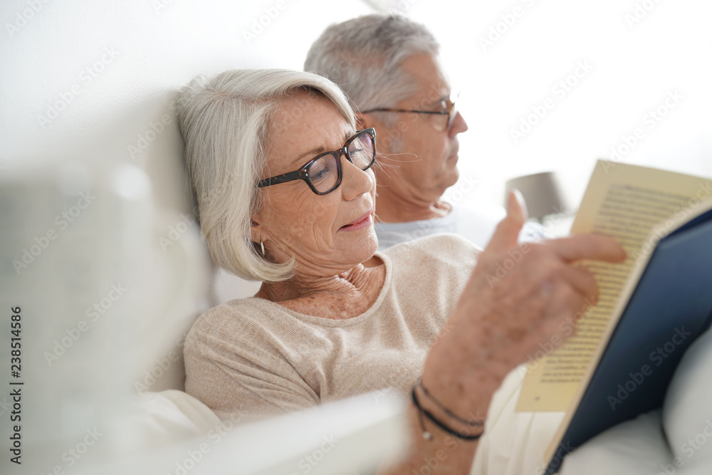  Senior couple relaxing and reading in bed