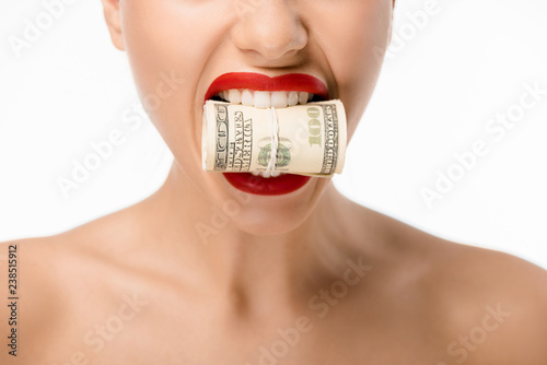 cropped shot of woman holding rolled dollar banknotes in teeth isolated on white