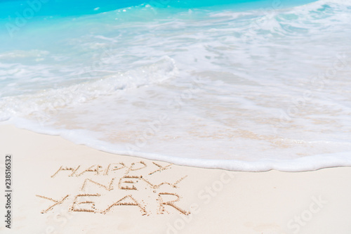 2018 inscription written on sandy beach, New Year greeting card.