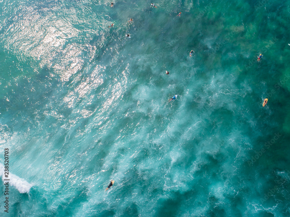 Aerial view from drone of surfers paddling for catching waves during surfing in the indian ocean Aerial view from drone of surfers paddling for catching waves during surfing in the indian ocean