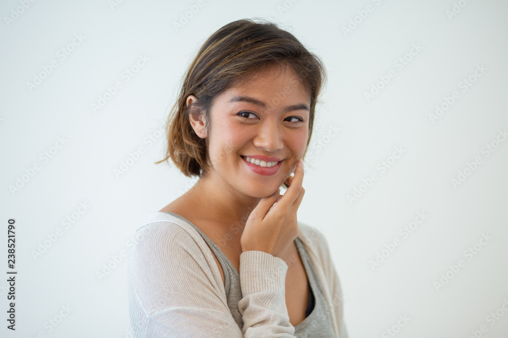 Portrait of flirty young Asian woman posing isolated. Chinese girl smiling and touching face. Beauty concept Portrait of flirty young Asian woman posing isolated. Chinese girl smiling and touching face. Beauty concept