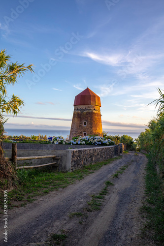 An old windmill next to a gravel road in the Feteiras on Sao Miguel. photo