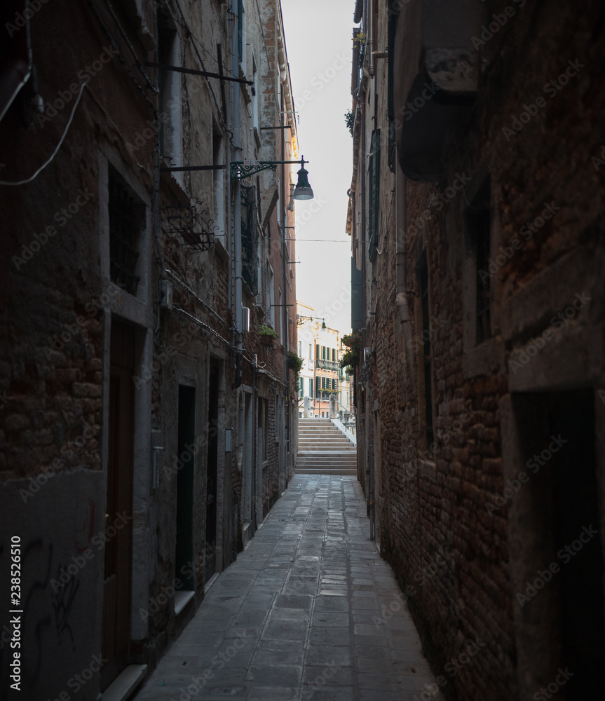 Narrow dark streets of Venice. Brick walls