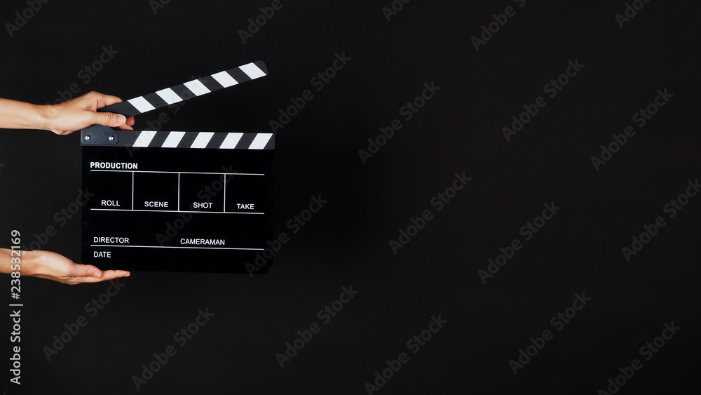 Two Hand's holding Clapperboard or movie slate use in video production ,film, cinema industry on black background.