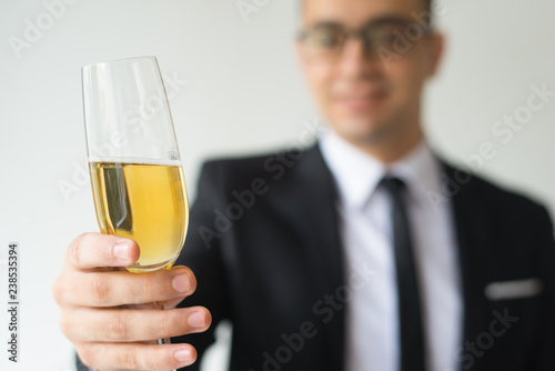 Closeup of business man toasting. Blurred person celebrating event. Holiday concept. Isolated cropped front view on white background.