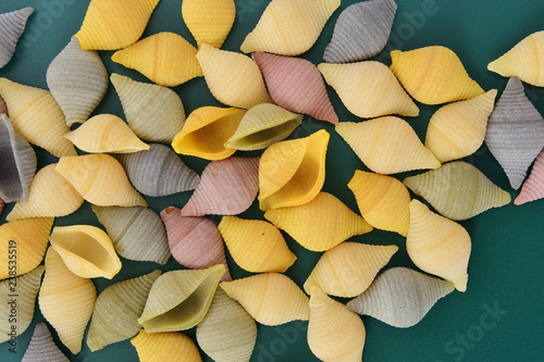 Pasta  conchiglie on green background photo