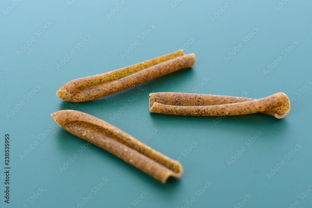 Pasta casarecce on green background