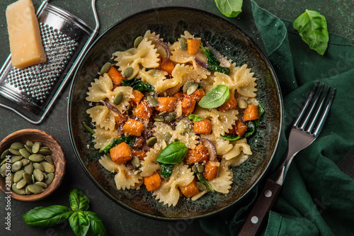 pumpkin farfalle pasta with pumpkin seeds and cheese in bowl