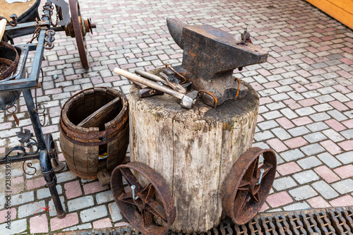 Vintage rusty anvil with blacksmith tools