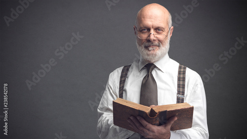 Cuadro en lienzo Academic professor smiling and reading a book