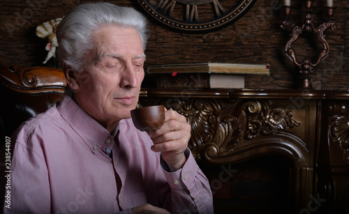 Close up portrait of senior man drinking tea photo