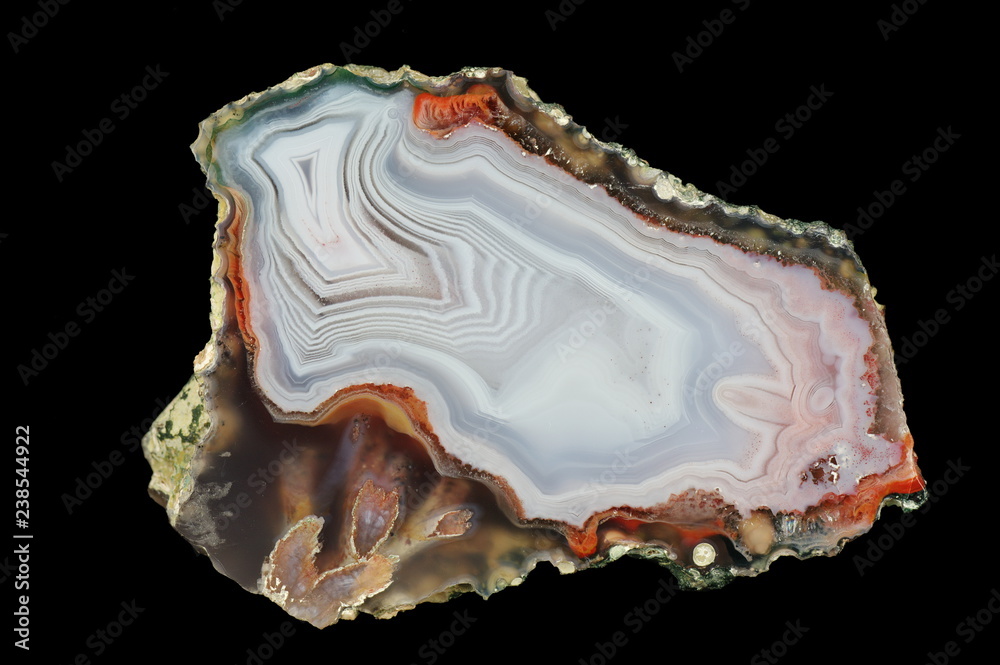A cross-section of agate. A snow-white chalcedony is interwoven with gray, transparent quartz, chalcedony lamination occurs in some places. Origin: Agouin, Atlas mountains, Morocco. A cross-section of agate. A snow-white chalcedony is interwoven with gray, transparent quartz, chalcedony lamination occurs in some places. Origin: Agouin, Atlas mountains, Morocco.