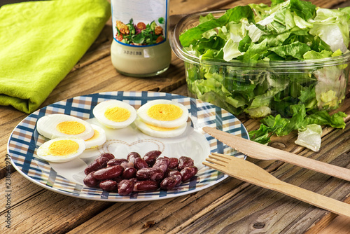 Wallpaper Mural Vegetarian salad of green leaves with egg and beans on a wooden table.	 Torontodigital.ca