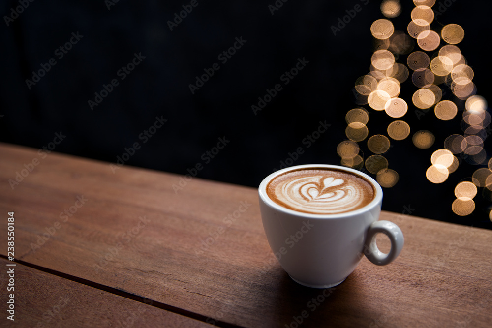 Fototapeta Smaczne cappuccino z rozmytymi światełkami z choinki.
