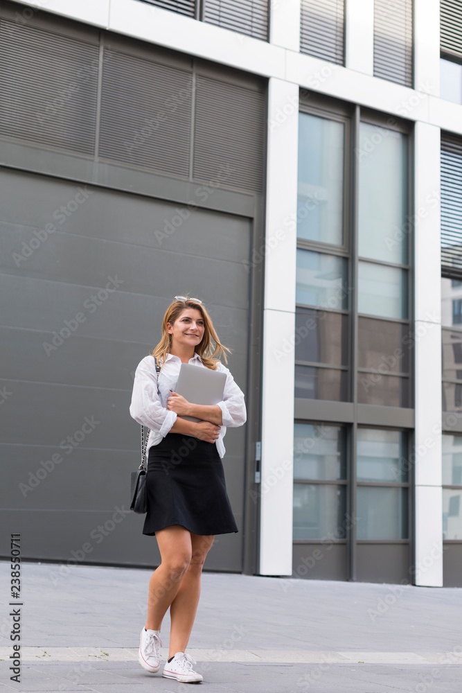 Portrait of content businesswoman with laptop outdoors Portrait of content businesswoman with laptop outdoors