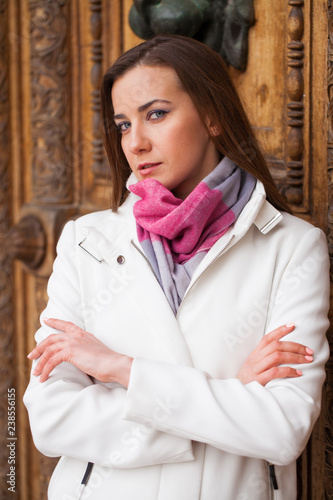 Portrait of a young beautiful woman in white classic coat