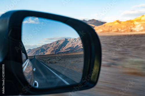 Diving through death valley highway at sunset, view through car mirror, landscape zooming by motion blur © Gabriel Cassan