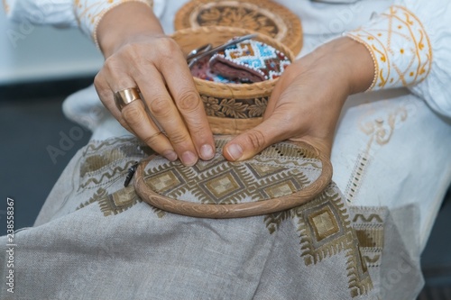 Photography Craft embroidery, woman's hands decorate handmade linen canvas with color thread