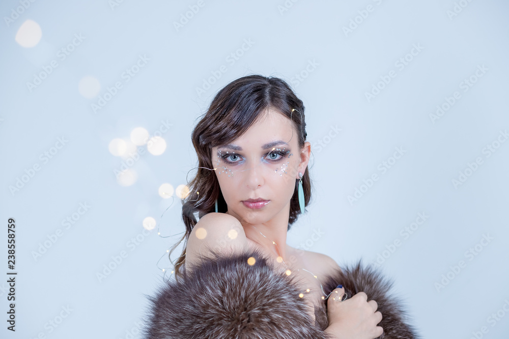 Dreaming winter woman looking up and wearing fur hat.Fashion portrait of beautiful sexy woman model with creative make-up in luxury fur coat.bare shoulders.Winter fashion sale.Luxurious brunette in Dreaming winter woman looking up and wearing fur hat.Fashion portrait of beautiful sexy woman model with creative make-up in luxury fur coat.bare shoulders.Winter fashion sale.Luxurious brunette in