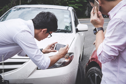 Canvas Print Two drivers man arguing after a car traffic accident collision and making phone