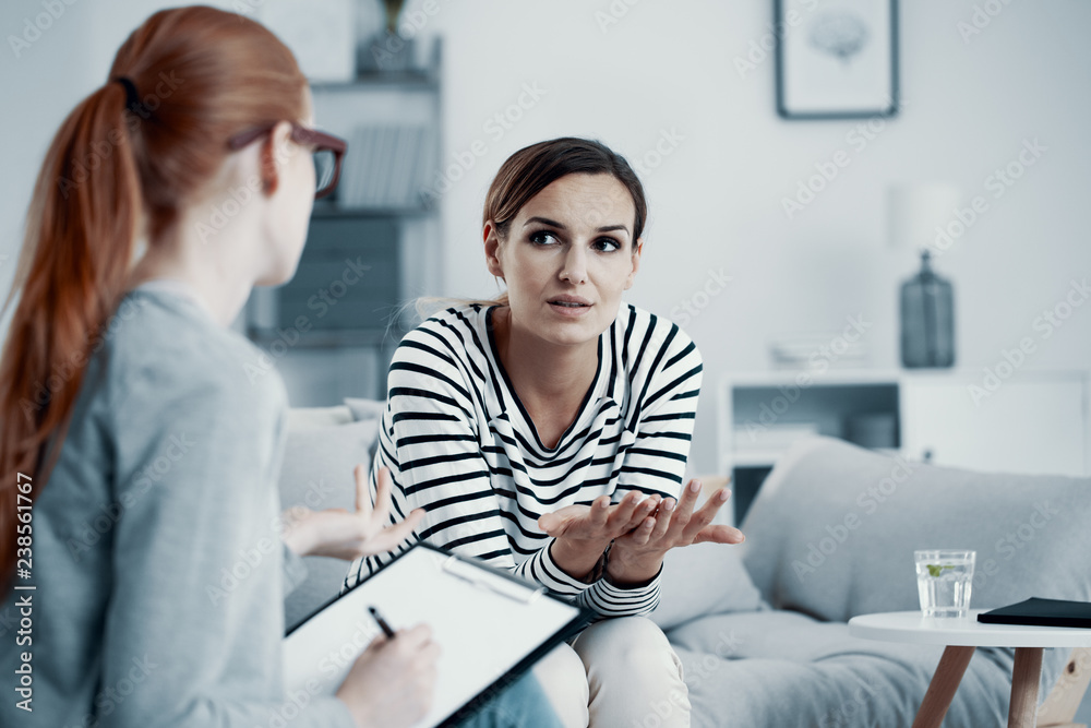 Unhappy woman suffering from depression during session at psychologist's office Unhappy woman suffering from depression during session at psychologist's office