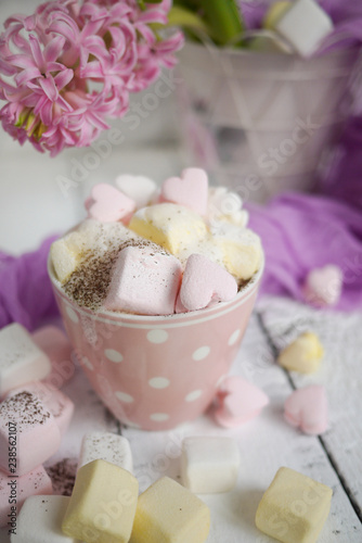 A cup of latte with hart-shaped marshmallows