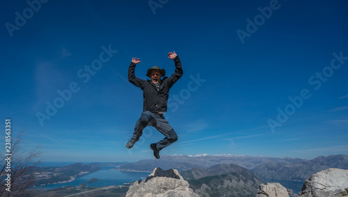 Tourist with a hat jumping high in the air
