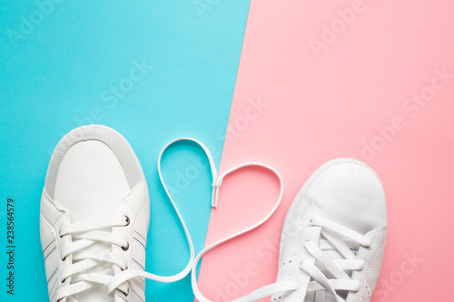 Obraz na plátne Heart created from white shoelaces between male and female sport shoes