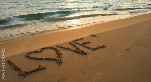 Valentines day concept  love heart shape handwriting on sand beach in sunrise and blue ocean.