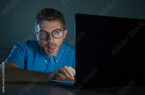 lascivious aroused porn addict man in nerd glasses watching sex movie online late night at laptop computer looking pervert and horny in internet pornography sex content photo