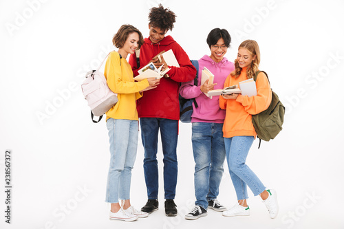 Young group of friends students standing isolated over white wall background posing.