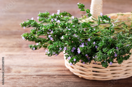 Fresh thyme in a basket over rustic wooden background with copyspace.