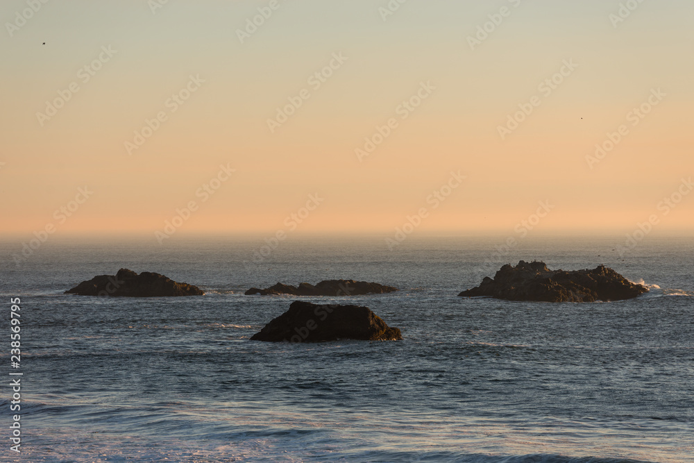 Islets protruding in the Pacific Ocean on a beach in Southern Oregon, USA