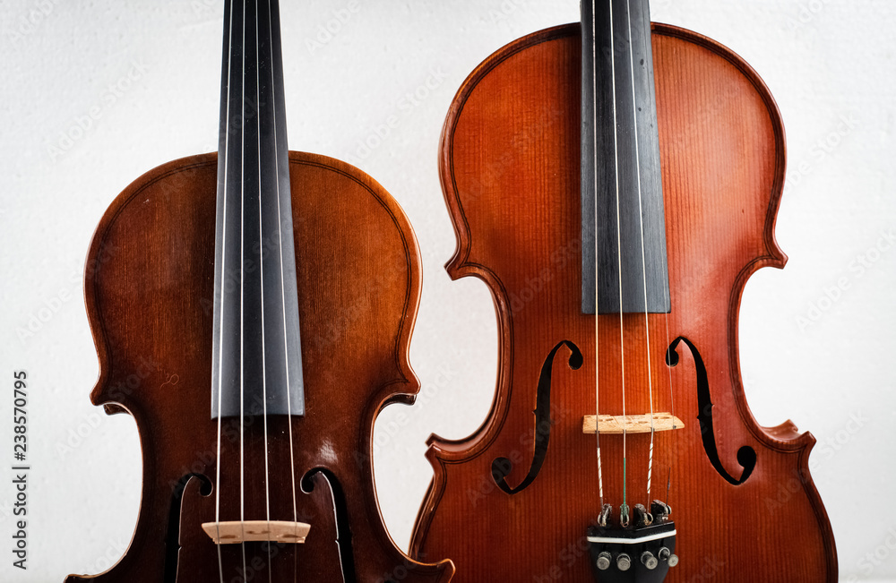 Two different size of violin put on background,show detail of front side, Two different size of violin put on background,show detail of front side,