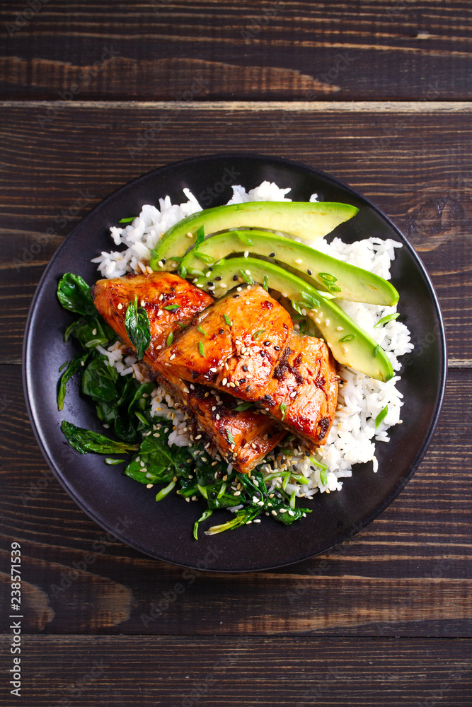 Salmon in honey-soy glaze with rice, spinach and avocado. overhead, vertical Salmon in honey-soy glaze with rice, spinach and avocado. overhead, vertical