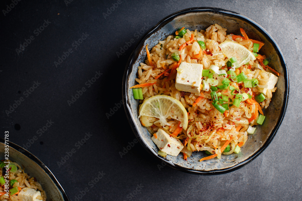 Vegetarian fried rice with tofu, peas and vegetables. Asian cuisine, healthy lunch, copy space