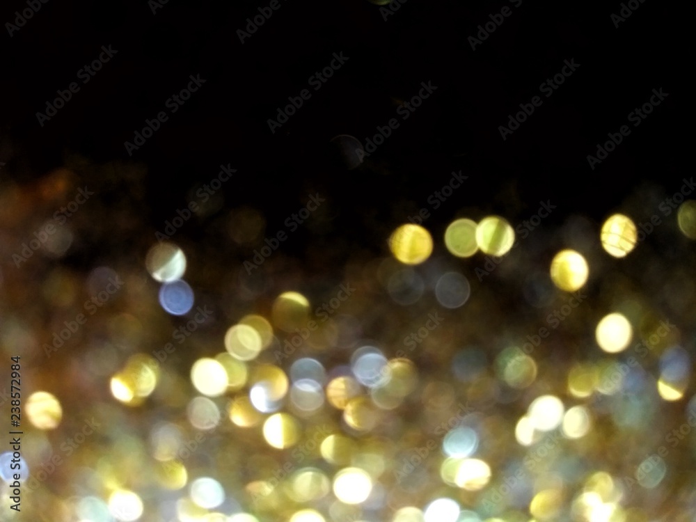 Obraz premium glittering blurred golden yellow round lights on a black background with area for copy space or text