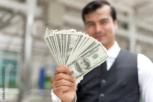 business man  holding money US dollar bills  on business  district urban , concept for success business