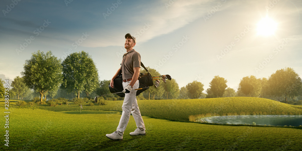 Male golf player on professional golf course. Smiling golfer walking on fairway with golf bag