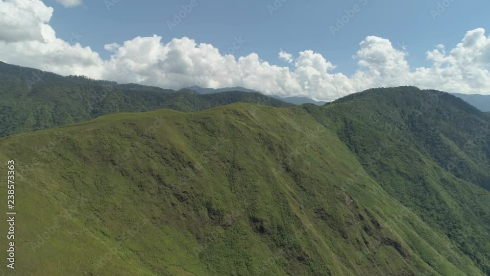 Aerial view of mountains covered forest, trees against the sky and clouds.Cordillera region. Luzon, Philippines. Mountainous tropical landscape.